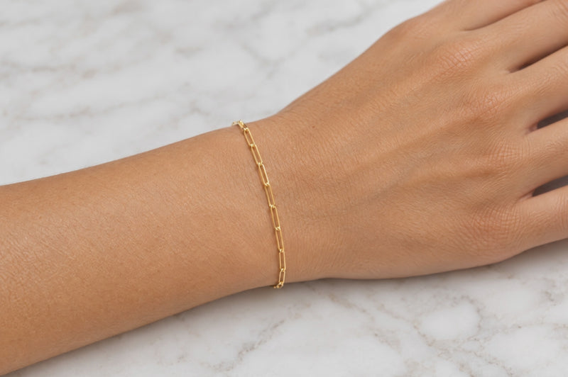 Load and play video in Gallery viewer, Sawyer 14K solid yellow gold 1.8 x 6mm paperclip chain worn as a welded permanent bracelet, video
