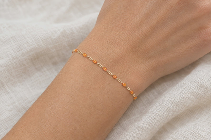 Load and play video in Gallery viewer, Harvest 14K gold filled paperclip chain with orange enamel stations, worn as a welded permanent bracelet, video
