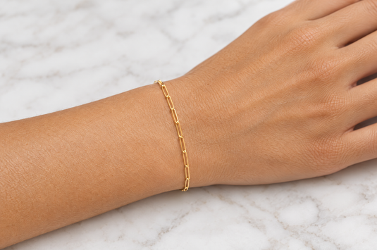 Sawyer 14K solid yellow gold 1.8 x 6mm paperclip chain worn as a welded permanent bracelet