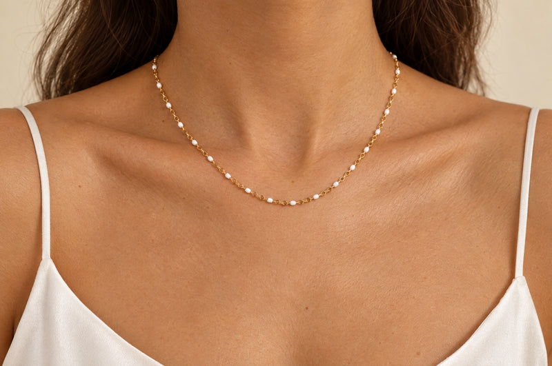 Cargue la imagen en el visor de la galería, Snow 1.6mm gold PVD stainless steel chain with white enamel beads worn as a permanent necklace
